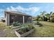 Home backyard featuring a screened in lanai with garden beds and lots of greenery at 3893 Wind Dancer Cir, St Cloud, FL 34772