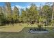 Expansive backyard boasting a verdant lawn, numerous trees, and a garden bed at 3893 Wind Dancer Cir, St Cloud, FL 34772