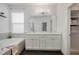 Bright bathroom featuring a soaking tub, double vanity, and a large mirror with a closet at 3893 Wind Dancer Cir, St Cloud, FL 34772