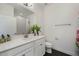 Bright bathroom featuring a vanity with a large mirror, toilet and decorative plants at 3893 Wind Dancer Cir, St Cloud, FL 34772