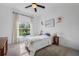 Bright bedroom featuring a large window with curtains, flowers and a ceiling fan at 3893 Wind Dancer Cir, St Cloud, FL 34772