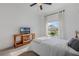 Cozy bedroom featuring a large window with curtains, flowers, a ceiling fan and TV stand at 3893 Wind Dancer Cir, St Cloud, FL 34772