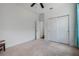 Spacious carpeted bedroom with a ceiling fan, closet doors, and access to another room at 3893 Wind Dancer Cir, St Cloud, FL 34772