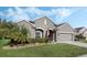 Well-maintained single Gathering home with neatly trimmed bushes, green lawn, and neutral colored exterior at 3893 Wind Dancer Cir, St Cloud, FL 34772