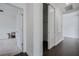 Hallway featuring wood-look floors, white walls and doors, with an open door to a carpeted room at 3893 Wind Dancer Cir, St Cloud, FL 34772