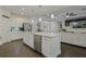 Open kitchen with white cabinets, quartz countertops, stainless appliances, and an island flows into the living area at 3893 Wind Dancer Cir, St Cloud, FL 34772