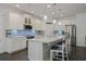 Charming kitchen features white cabinetry, quartz counters, stylish pendants, and stainless steel appliances at 3893 Wind Dancer Cir, St Cloud, FL 34772