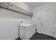 View of a white laundry room with a washer and dryer, overhead shelving, and a door at 3893 Wind Dancer Cir, St Cloud, FL 34772