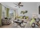 Bright living room featuring a ceiling fan, neutral furniture, decorative pillows, and natural light from the window at 3893 Wind Dancer Cir, St Cloud, FL 34772