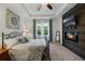 Main bedroom showcasing a decorative accent wall, fireplace, tv, tray ceiling, and ensuite bath access at 3893 Wind Dancer Cir, St Cloud, FL 34772