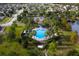Aerial view of a community pool surrounded by lush landscaping and palm trees, offering a luxurious and resort-like atmosphere at 3893 Wind Dancer Cir, St Cloud, FL 34772