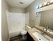 Bright bathroom features a tub with shower, grey walls, and sink with granite countertop at 3922 Crayrich Cir # C-4, Orlando, FL 32839