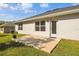 Backyard view shows concrete patio, lush green grass, and an exterior door, creating a private outdoor space at 442 Big Black Pl, Kissimmee, FL 34759