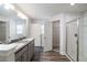 Bright bathroom featuring double sinks, a shower, and wood-look floors at 442 Big Black Pl, Kissimmee, FL 34759
