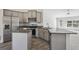 A spacious kitchen has stainless steel appliances, granite countertops, and a peninsula with a sink and bar seating at 442 Big Black Pl, Kissimmee, FL 34759