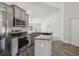 The kitchen has stainless steel appliances, a granite-topped island, and a ceiling fan view to the adjacent living room at 442 Big Black Pl, Kissimmee, FL 34759