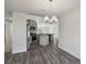Chandelier over the dining table, stainless steel appliances, and a kitchen with gray cabinets, and wood-look floors at 442 Big Black Pl, Kissimmee, FL 34759