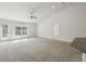 Bright living room featuring plush carpeting, abundant natural light, and a modern ceiling fan at 442 Big Black Pl, Kissimmee, FL 34759