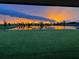 Breathtaking sunset view over a pond with green lawn, showcasing serene backyard living at 4512 Cutwater Dr, Orlando, FL 32820