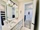 Bathroom with double sinks, white cabinetry, and views into the bedrooms at 4512 Cutwater Dr, Orlando, FL 32820