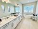 Bright bathroom features double sinks, soaking tub, lots of light and neutral decor at 4512 Cutwater Dr, Orlando, FL 32820