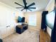 A cozy bedroom space featuring a ceiling fan, a wooden desk, and neutral carpeting at 4512 Cutwater Dr, Orlando, FL 32820