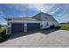 Rear exterior view showcasing a spacious three-car garage and neutral color scheme at 4512 Cutwater Dr, Orlando, FL 32820