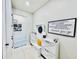 Bright foyer with white storage bench, coat rack and inspirational decor at 4512 Cutwater Dr, Orlando, FL 32820