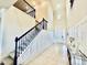 Inviting foyer featuring high ceilings, tiled floors, staircase with iron railing, and wainscoting detail at 4512 Cutwater Dr, Orlando, FL 32820