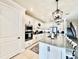This white kitchen has an island with seating, stainless appliances and stairs to the upper level at 4512 Cutwater Dr, Orlando, FL 32820