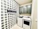 Well-equipped laundry room with modern appliances and stylish buffalo check wallpaper at 4512 Cutwater Dr, Orlando, FL 32820