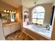 Bathroom with a jetted tub under a chandelier and a marble vanity at 4638 River Ridge Dr, Leesburg, FL 34748