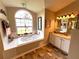 Bathroom with a jetted tub, chandelier, and vanity with a marble countertop at 4638 River Ridge Dr, Leesburg, FL 34748