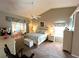 Main bedroom with vaulted ceiling, carpet flooring, and sliding door access to lanai at 4638 River Ridge Dr, Leesburg, FL 34748