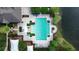 An aerial view of a community pool with lounge chairs near a lake at 4730 Capital Blvd, St Cloud, FL 34769