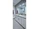 Bathroom with gray tiling, granite countertop, decorative backsplash, and enclosed shower reflected in mirror at 4730 Capital Blvd, St Cloud, FL 34769