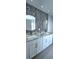 Bathroom featuring modern design, double sinks, decorative backsplash, and granite countertops at 4730 Capital Blvd, St Cloud, FL 34769