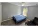 Cozy bedroom with a large window, ceiling fan, and hardwood floors at 4730 Capital Blvd, St Cloud, FL 34769