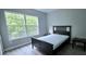 Bedroom featuring a large window, wood-look floors, and dark-color furniture at 4730 Capital Blvd, St Cloud, FL 34769