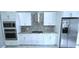 Modern kitchen with stainless steel appliances, white cabinetry, and stylish backsplash at 4730 Capital Blvd, St Cloud, FL 34769