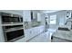 Modern kitchen with stainless steel appliances, white cabinetry, stylish backsplash, and ample counter space at 4730 Capital Blvd, St Cloud, FL 34769