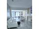 Spacious living room featuring modern white furniture and an open floorplan leading to the dining area at 4730 Capital Blvd, St Cloud, FL 34769
