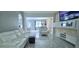 Bright, open-concept living room featuring modern white furniture, tiled floors, and stylish wall accents at 4730 Capital Blvd, St Cloud, FL 34769