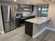 Bright kitchen with stainless steel appliances, an island with counter seating, and hardwood floors at 5237 Davisson Ave, Orlando, FL 32810