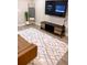 Bright living room with modern gray patterned rug, TV, and a brown sofa at 5237 Davisson Ave, Orlando, FL 32810