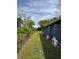 A view of the exterior side yard, grass, and AC units of the home on a sunny day at 5237 Davisson Ave, Orlando, FL 32810
