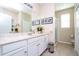 Bright bathroom with white cabinetry, marble countertops, framed artwork, and a glass shower enclosure at 6008 Golden Dewdrop Trl, Windermere, FL 34786