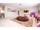 Spacious and sunny bonus room with carpeting and a large brown beanbag chair on a patterned rug at 6008 Golden Dewdrop Trl, Windermere, FL 34786