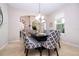 Dining room with modern table, patterned chairs, and a view of the staircase and front door at 6008 Golden Dewdrop Trl, Windermere, FL 34786