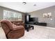 Cozy living room with a large window, entertainment center and comfortable reclining sofa at 6008 Golden Dewdrop Trl, Windermere, FL 34786